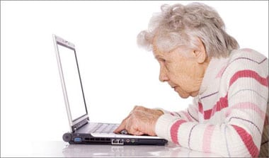Äldre dam läser sin journal vid dator