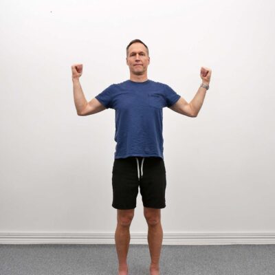 Armarna lyfts något över axelhöjd med bibehållen armbågsvinkel.