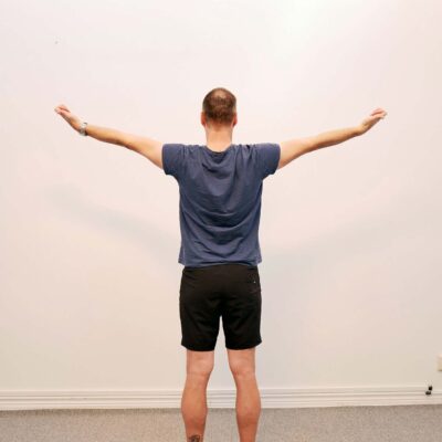 Armarna förs snett utåt med bibehållen kontroll i skulderblad.