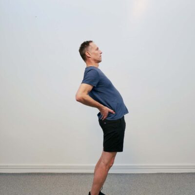 Mellanposition: Personen lutar överkroppen bakåt med lätt bakåtböjning i ländryggen.